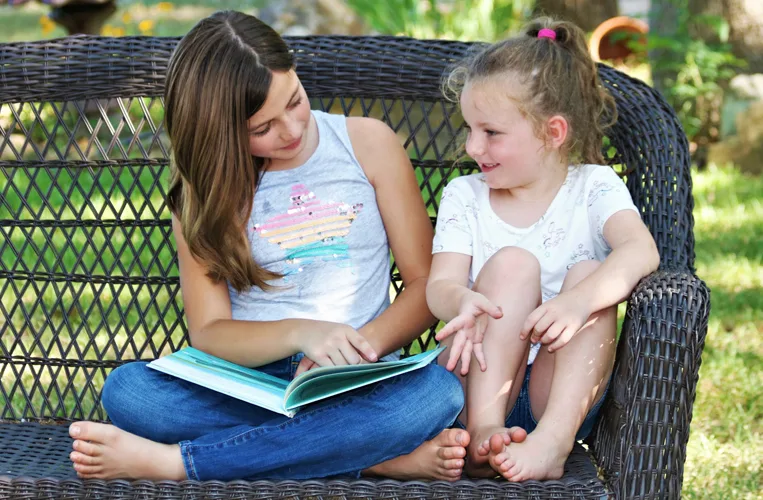 Two children reading outdoors